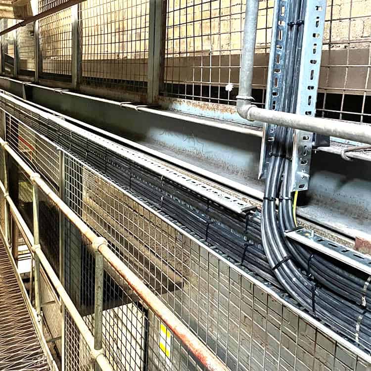 Multiple electrical cables wired into electrical cable runs on industrial site